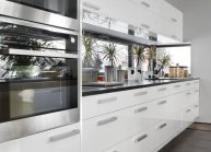 Moderní rodinný dům s dominantními střešními okny – detail bílé kuchyňské linky.